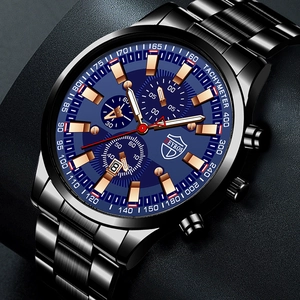 Detail of blue chronograph watch face with gold markers and luminous hands