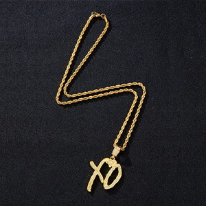 Detailed close-up of golden hip hop chain with iced-out XO heart pendant and lobster clasp
