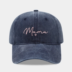 Close-up of pink Mama embroidery and heart detail on navy washed denim baseball cap