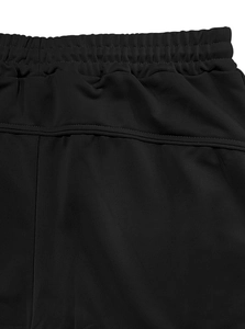 Dettaglio della fascia elastica in vita e cuciture rinforzate sui pantaloni sportivi neri