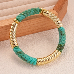 Gros plan de perles torsadées en acrylique turquoise et métal doré sur un bracelet