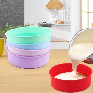 Detailed view of colorful silicone baking molds being filled with cake batter on a table