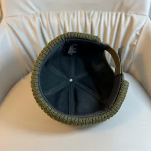Close-up of the green Miki hat interior showing black lining and brown adjustable strap