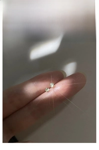 Close-up of minimalist s999 silver stud earrings with sparkling colored cubic zirconia