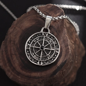 Macro view of silver alloy compass pendant necklace on textured wood background