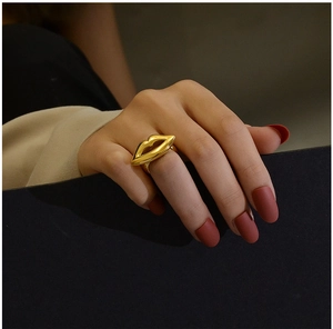 Close-up of a 18K gold plated lip shaped ring worn on hand with a high polish finish