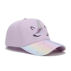 Detail of unicorn embroidery and rainbow glitter brim with star sequins on a kids hat