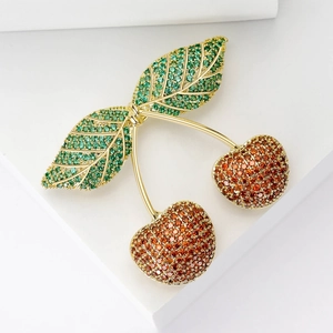 Elegant cherry brooch with gold base and micro-paved red and green cubic zirconia
