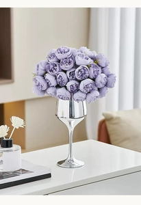 Detalle de rosas lavanda artificiales en un jarrón de cáliz plateado de lujo