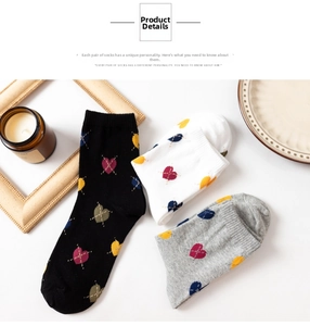 Detail of heart pattern crew socks in black, white, and grey with ribbed cuffs
