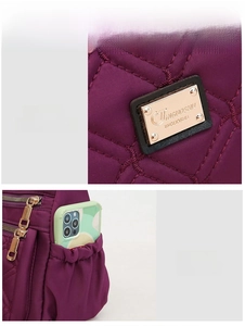 Detail of purple quilted nylon bag featuring a side elastic pocket holding a smartphone