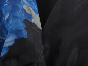 Dettaglio della stampa organza floreale e tessuto satin nero sul vestito a V