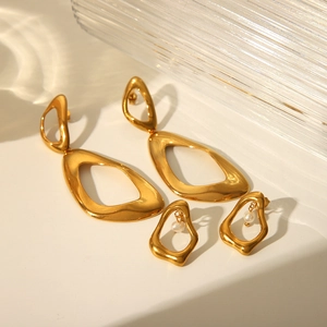 Detailed view of gold geometric earrings set with hollow triangles and elegant pearls