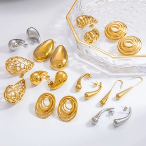 Detailed close-up of hollow spiral and teardrop stainless steel earrings in gold and silver