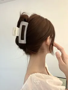 Detailed view of a large frosted translucent white rectangular hair claw clip for bun styles