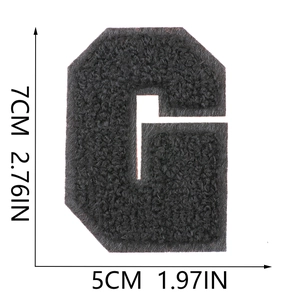 Macro shot of 7cm black chenille letter G patch with dimensions and texture details