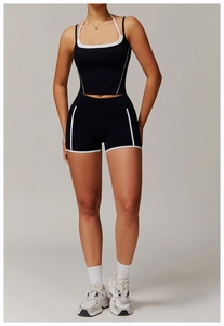 Detail eines schwarzen Sportsets mit weißen Paspeln und Yoga-Shorts mit hohem Bund