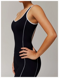 Seitenansicht des schwarzen Yoga-Bodysuits mit weißen Kontrastnähten und Schlaghose