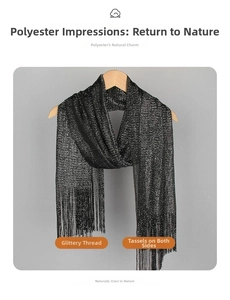 Detail of black metallic yarn scarf featuring fringe tassels on a wooden hanger
