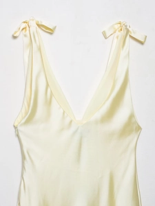 Detail view of cream satin midi dress with delicate shoulder ties and silk texture finish
