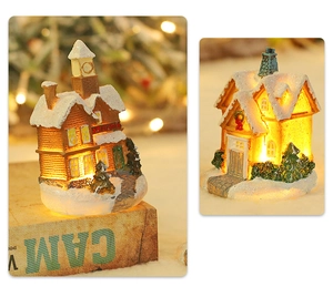 Detail of miniature Christmas village house with LED lights and snow-covered resin finish