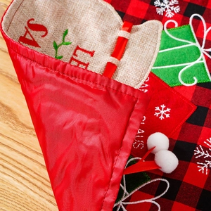 Gedetailleerde weergave van kersttafelloper met rood ruitpatroon en feestelijk borduursel