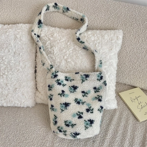 Close-up of floral lamb wool bucket bag with soft fleece texture and long shoulder strap