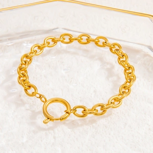 Detailed close-up of golden stainless steel curb chain bracelet with spring ring clasp