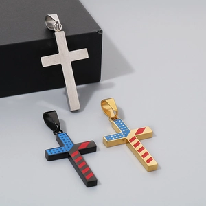 Detailed view of silver, black, and gold stainless steel American flag cross pendants