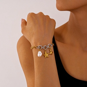 Detail of beach style bracelet with gold starfish, octopus charms and a baroque pearl