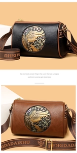 Detail of vintage embossed elephant emblem on textured leather crossbody bags