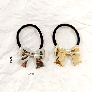 Close-up of gold and silver hollow bow hair ties with detailed size measurements