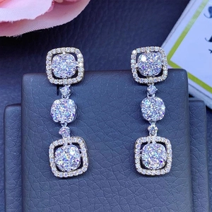 Detailed macro view of luxurious long silver drop earrings with square zircon crystals