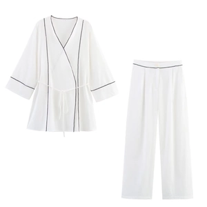 Elegant white two-piece set with black piping, belted V-neck top and trousers