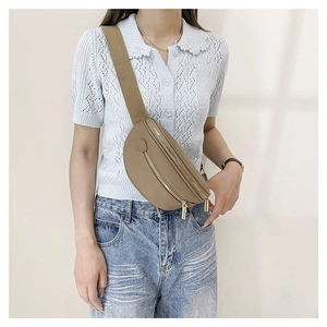 Detail of khaki crescent leather crossbody bag with lychee texture and gold zippers