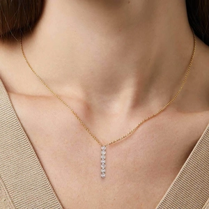 Elegant gold chain necklace with a vertical seven-stone zircon bar pendant worn by model