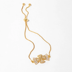 Detail of adjustable gold bracelet with sparkling zircon cross design and slider clasp