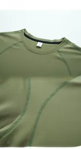 Détail du t-shirt vert olive à col rond montrant des coutures plates et l'étiquette XL