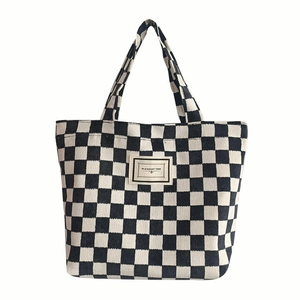 Classic black and white checkered corduroy tote bag with double handles and logo patch