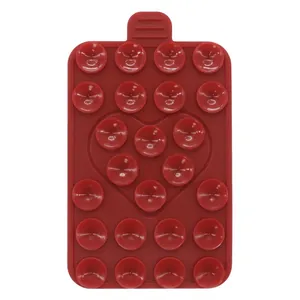 Detail view of red silicone heart suction cup phone pad with dual-sided grip surface