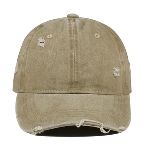 Detail of distressed khaki cotton baseball cap with vintage frayed holes and worn texture