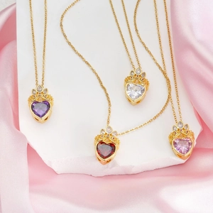 Elegant titanium steel heart crown necklaces in multiple colors on pink silk background