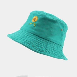 Détail de la broderie tournesol et œillet métallique sur chapeau bob turquoise