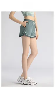 Detail of dark green high-waisted gym shorts with breathable mesh panels and white drawstrings