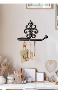 European vintage cast iron wall rack with ornate scroll design and hanging bar