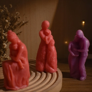 Artistic mother-child and couple candles in coral pink and purple with warm lights