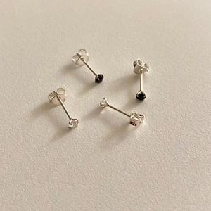 Detailed view of S925 silver stud earrings with black and clear four-prong cubic zirconia