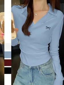Schmal geschnittenes hellblaues Langarm-Poloshirt mit schwarzer Schleifenstickerei