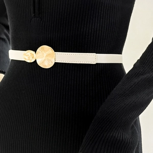Close-up of white leather belt with double gold circular buckles on a black dress