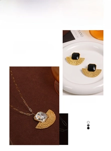 Detail showing fan-shaped gold jewelry with black and clear stones in a macro view